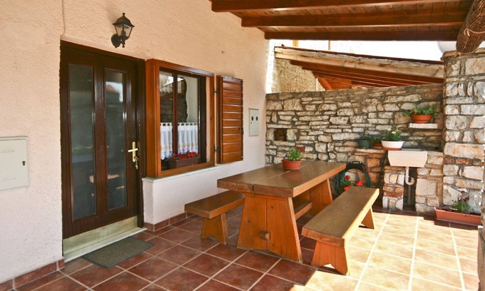 Orihi Casa | Casa rústica de piedra con parasol en una finca vallada