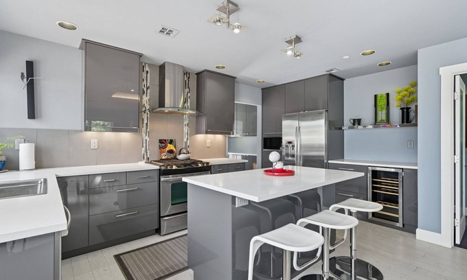 Hough Apartamento | Top-level duplex featuring a sleek open concept kitchen with stainless appliances, cozy fireplace, stylish furnishings, and in-unit washer/dryer. Designed for basking in the sun under skylights in thoughtful details throughout.
