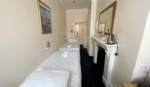 Habitación básica con 2 camas individuales, baño compartido