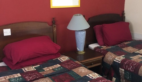 Habitación básica con 2 camas individuales, baño compartido