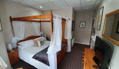 Cama matrimonial con dosel, baño privado