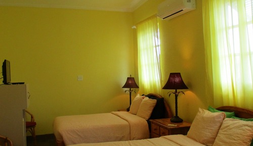 Habitación familiar, varias camas, baño privado, vistas parciales al mar