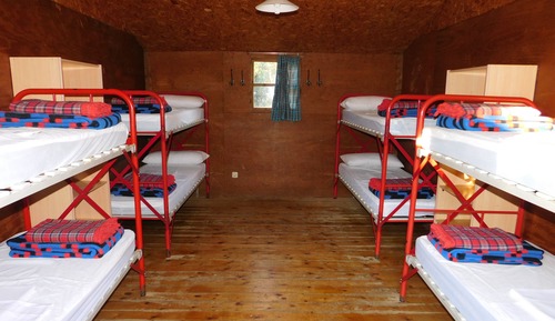 Cabaña de madera con baño exterior compartido